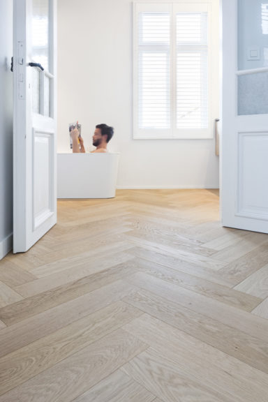 Lichte visgraat parketvloer in de badkamer